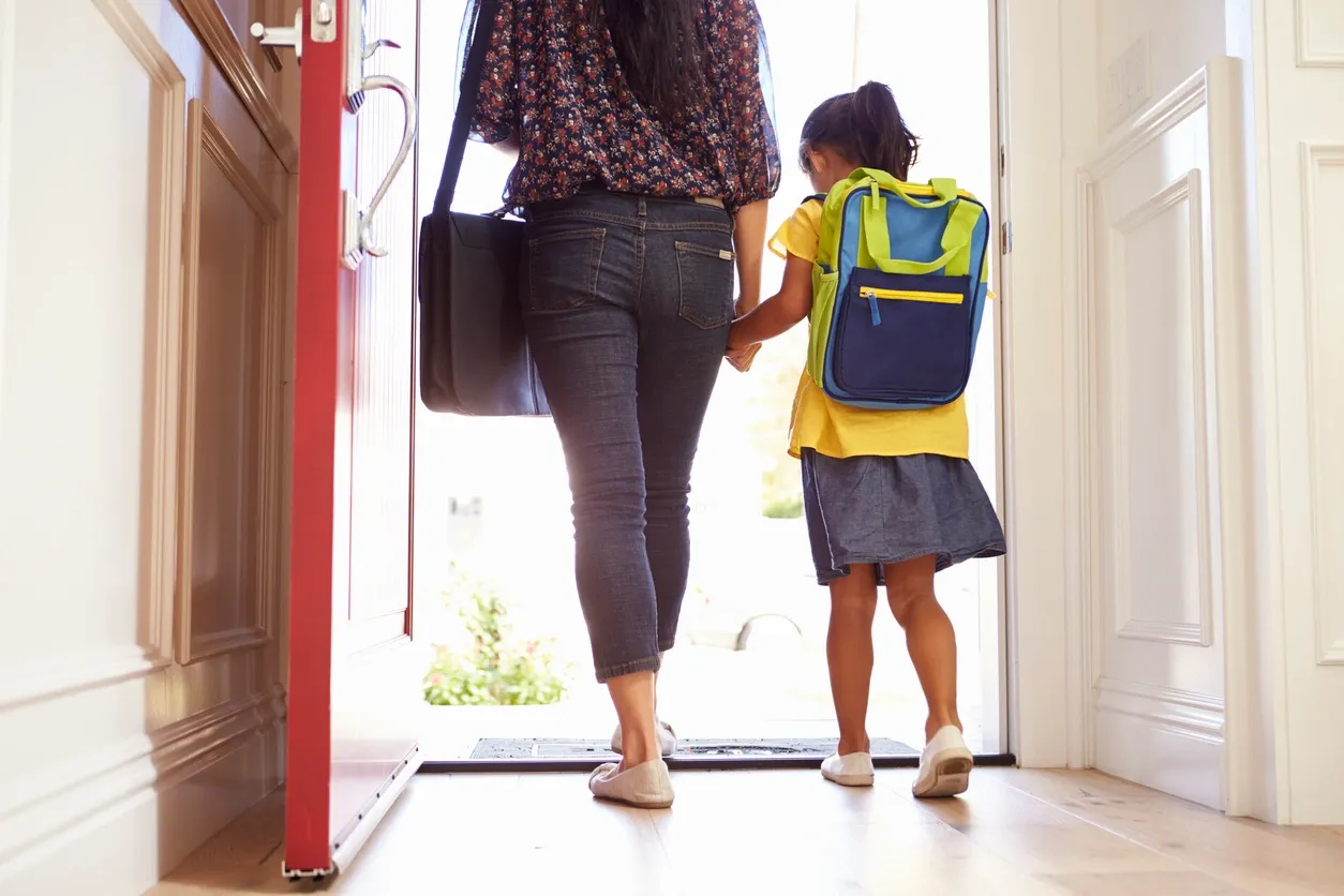 A mother is taking her daughter out of her house