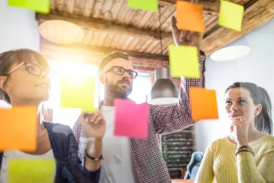 3 colleagues looking at the sticky notes