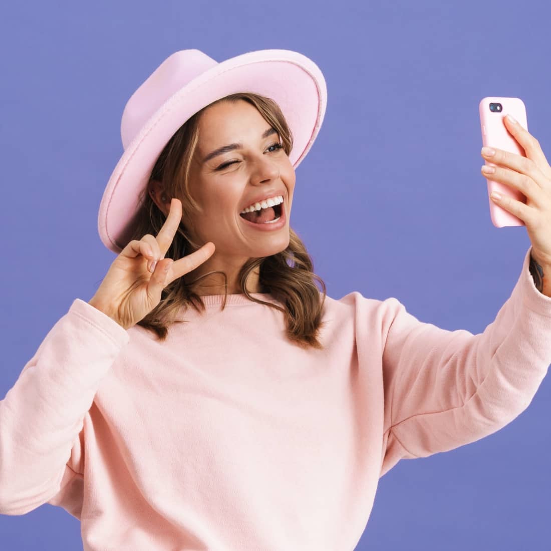 cheerful woman wearing a pink hat and pink outfit