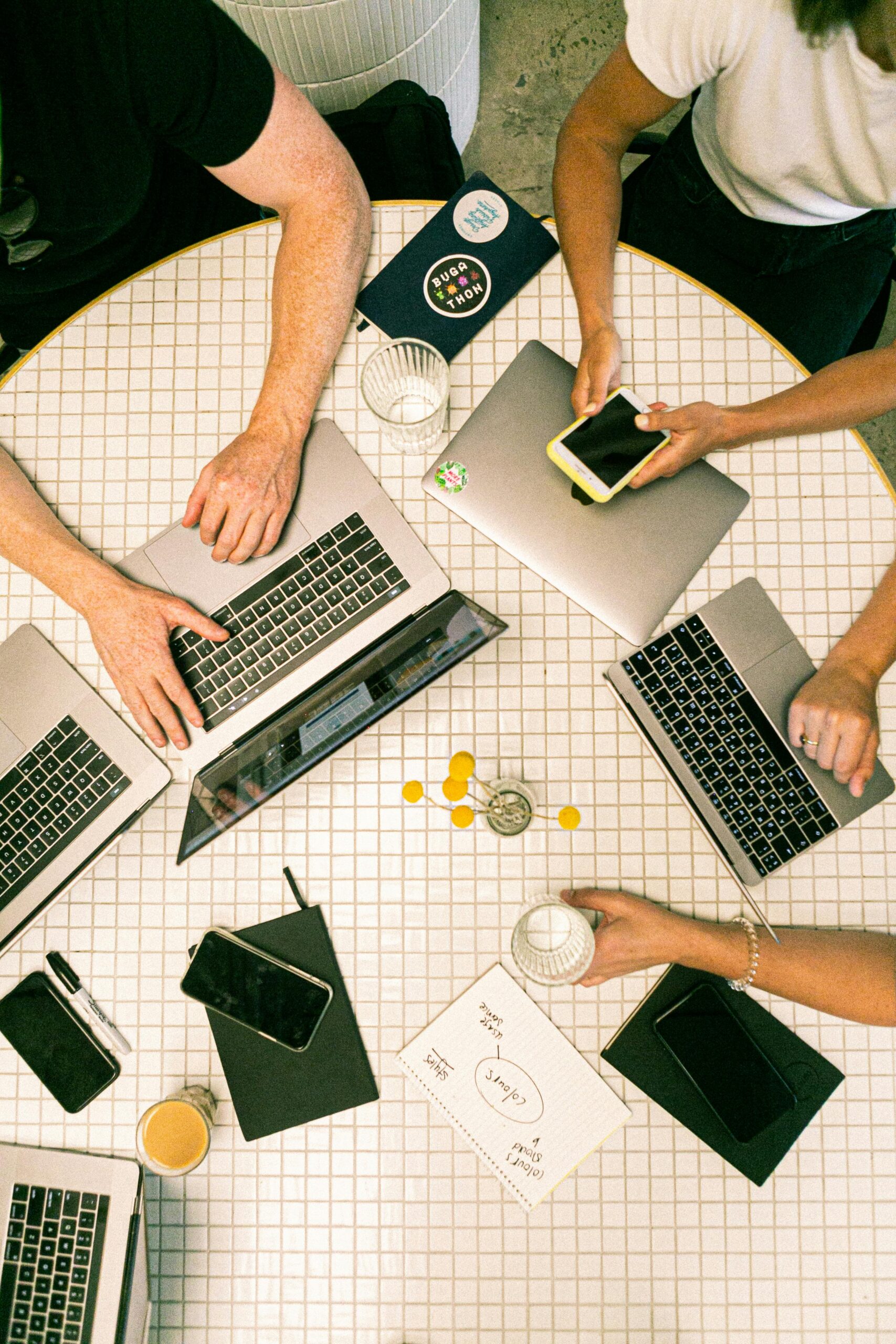 group of people working on laptops around a table