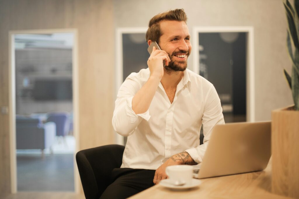 businessman talking on the phone while working on a laptop